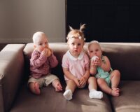 group-funny-cute-children-sitting-together-couch-playing-with-colorful-balls-three-happy-kid-boy-girl-colored-clothing-posing-comfortable-sofa-full-shot