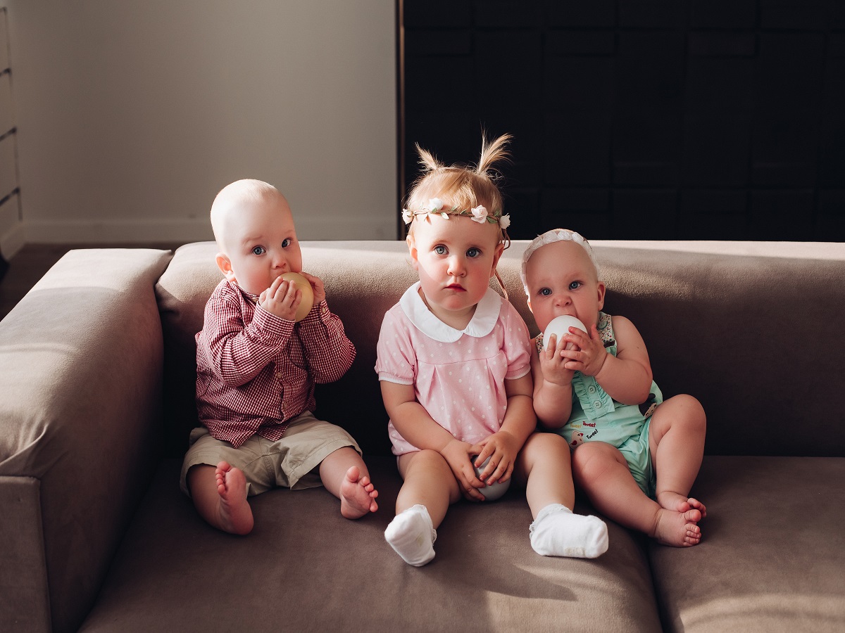 group-funny-cute-children-sitting-together-couch-playing-with-colorful-balls-three-happy-kid-boy-girl-colored-clothing-posing-comfortable-sofa-full-shot